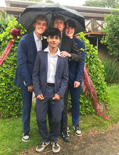 Gallafest efterskole - fire festklædte drenge under paraply