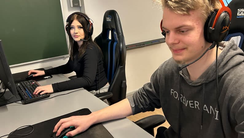 Pige og dreng spiller computer på efterskolens eSportslinje