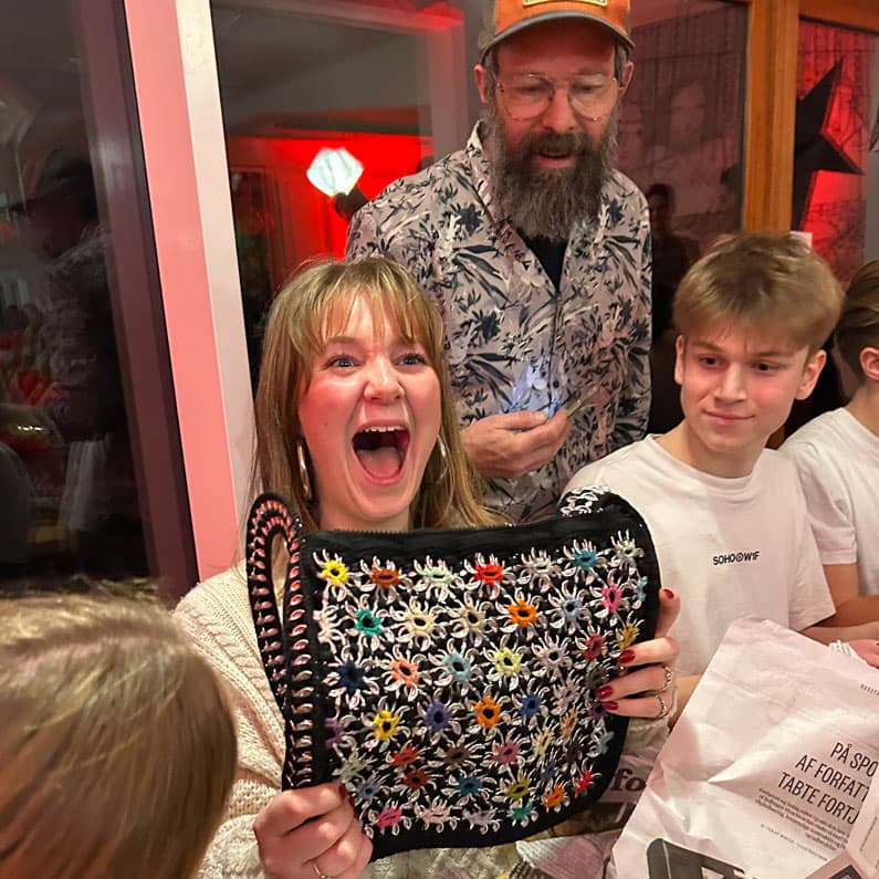 Begejstret efterskoleelev åbner pakke i julepakkeleg