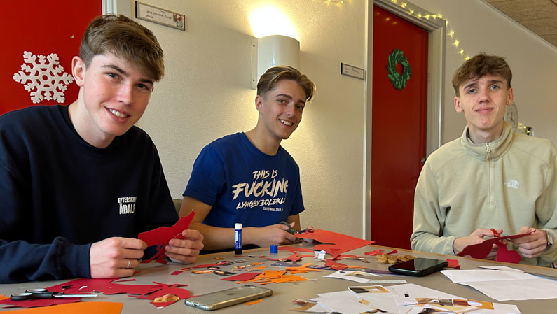 Tre drenge hygger sig med juleklip på efterskolen